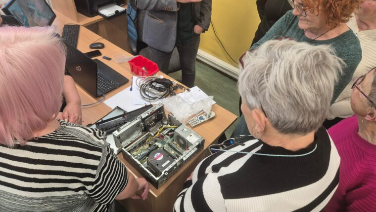 Grupa osób stoi przed elementem elektronicznym